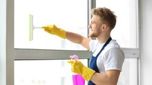 Mann putzt Fenster